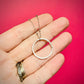 Hand holding a silver halo circle pendant against a pink background | Silverlicious Artisan Jewellery