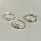Three adjustable silver rings with different textures and one with a star design, displayed on a light background.