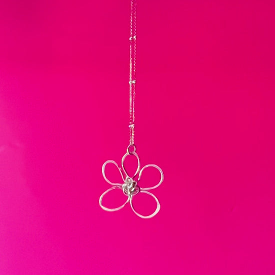 Whimsical Bloom Silver Flower Pendant turning against a pink background | Silverlicious Artisan Jewellery