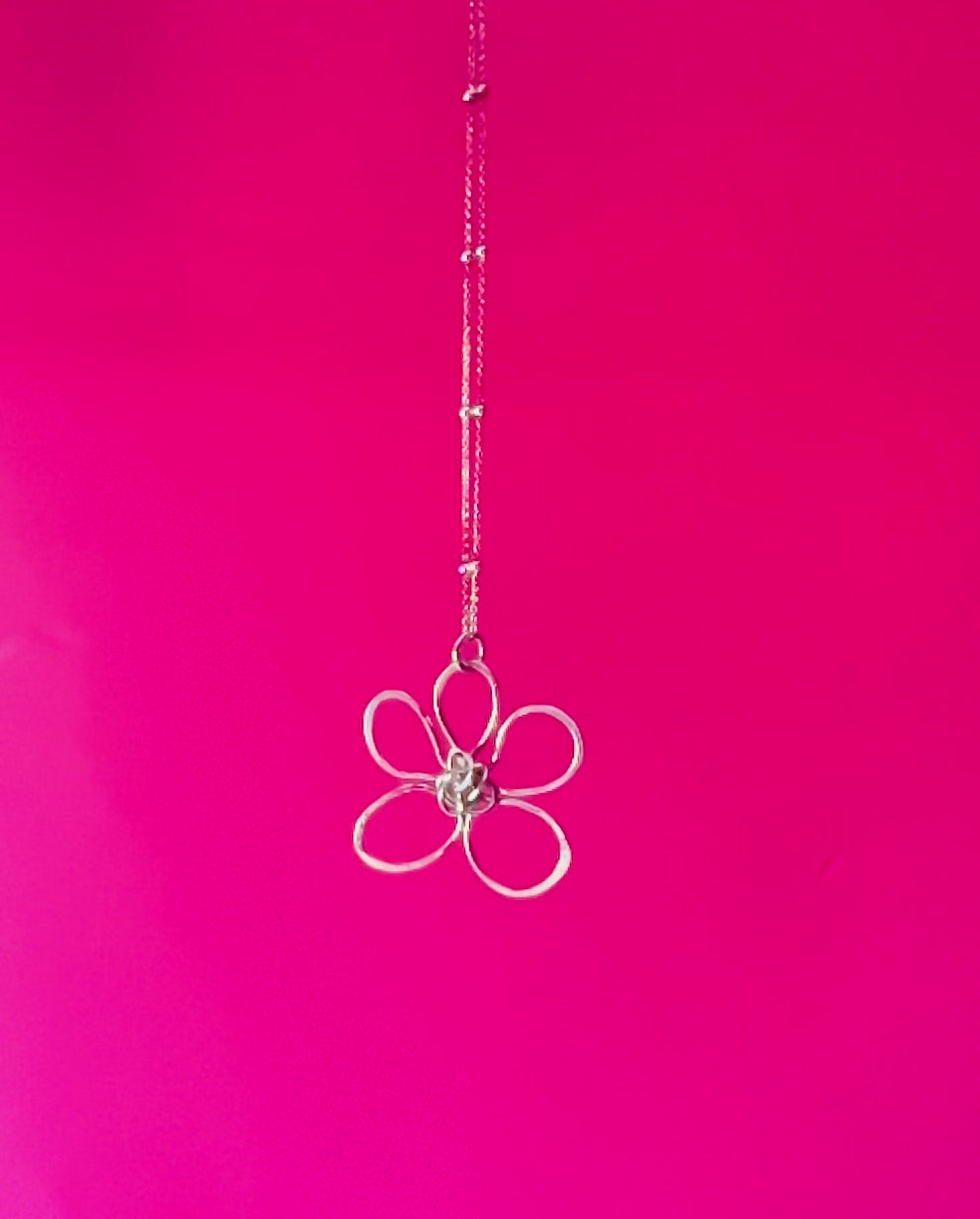 Whimsical Bloom Silver Flower Pendant turning against a pink background | Silverlicious Artisan Jewellery